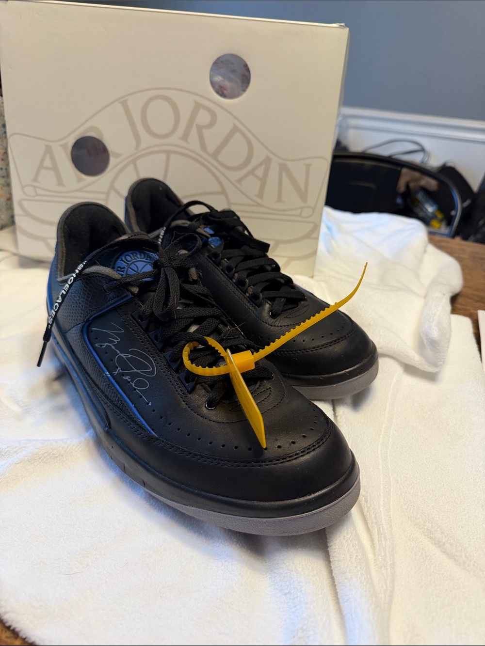 Air Jordan 2 Retro Low Black Sneakers with MJ’s signature and tag.